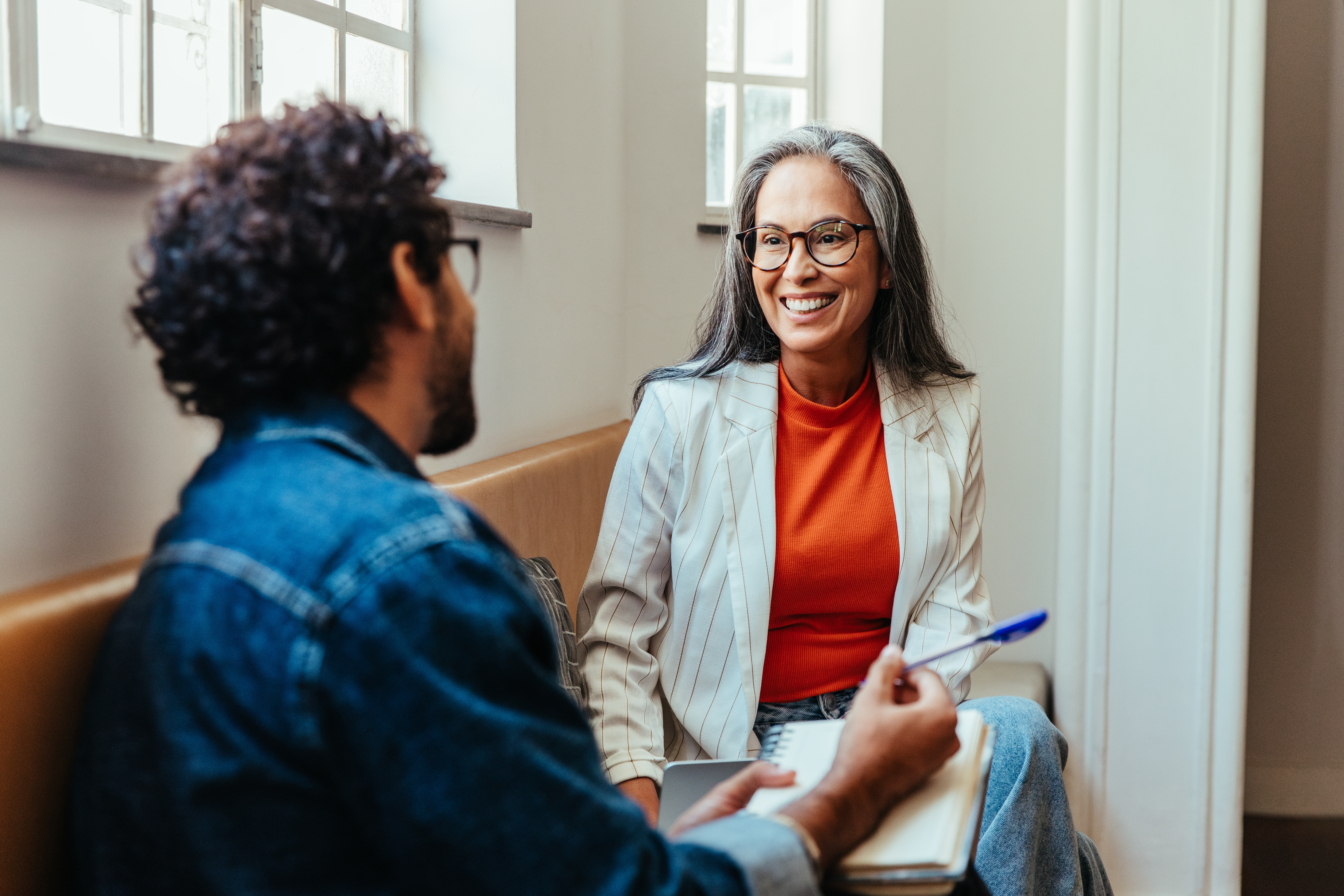 Coworkers having a creative discussion in the office lounge area. (Adobe Stock)