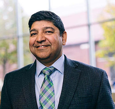 Sunil Prabhakar, professor and head, stands in front of a window.