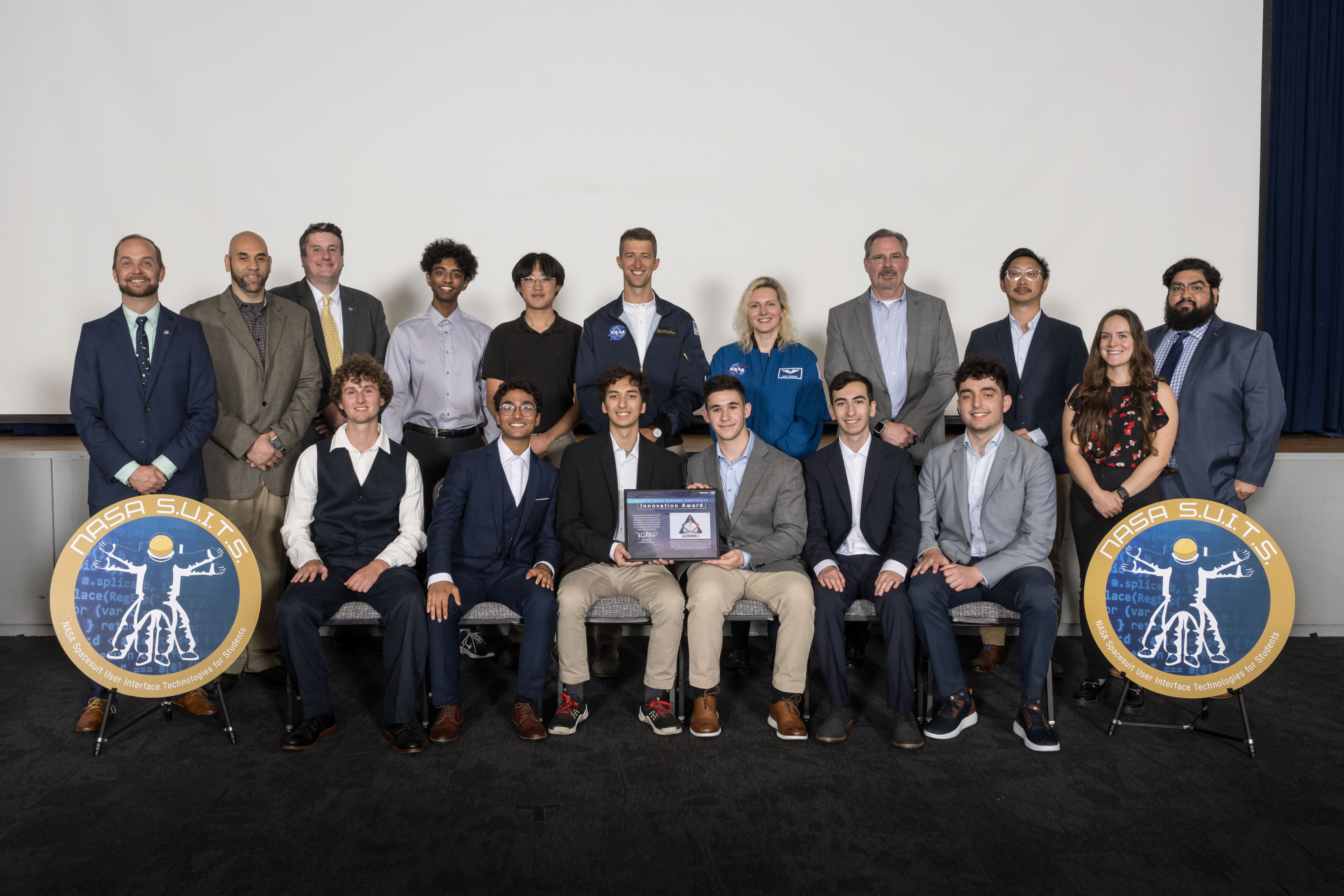 From left to right: Anand Shanker, Peter Zakariya, Max Xu, Paul Greenberg, Conor Ebeling, Swastik Patel, Zach O’Connell, and Benji Emini, pictured with NASA Astronaut Deniz Burnham (center, between Paul and Conor), receive the Innovation Award at NASA’s Johnson Space Center. Photo Credit: NASA - David DeHoys