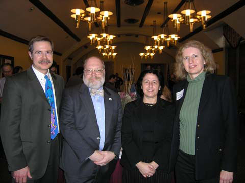 Dean Jeff Vitter (left) and Department Head Susanne Hambrusch (right) celebrate with Professor Eugene Spafford and Professor Elisa Bertino