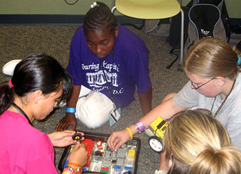 Campers construct Lego robots which they will program to knock down bowling pins.