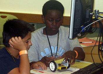 Campers construct Lego robots which they will program to knock down bowling pins.