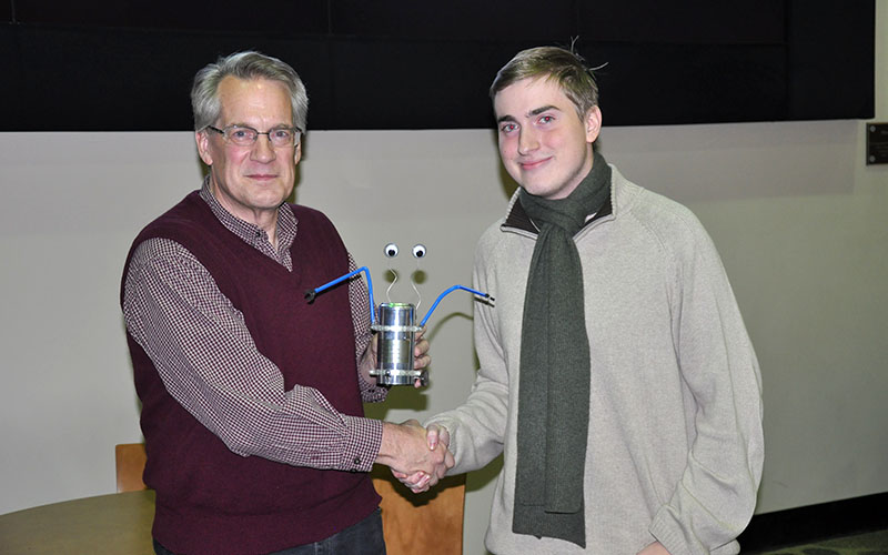 Tim Korb presents Nathaniel Cherry with a charming trophy to recognize his third place finish in the finals.