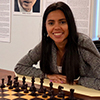 Nadya Ortiz, (MS in CS, 2014) poses behind a chess board.