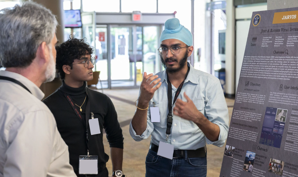  From right to left: Gurmehar Singh and Swastik Patel explain the team’s work to NASA Employees at last year’s SUITS Test Week Poster Session in May 2024. Photo Credit: NASA - James Blair